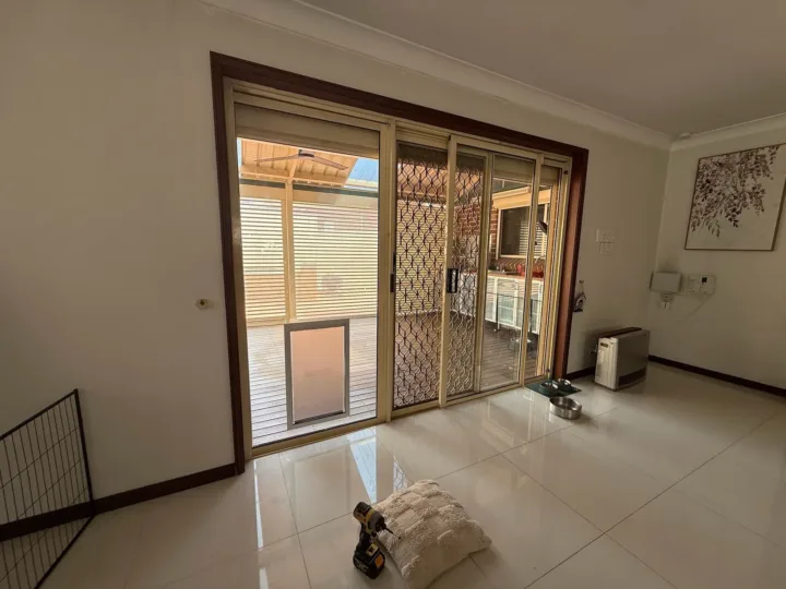 An extra large dog door in a sliding glass door in a lounge room